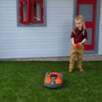 Barn som leker med robotgräsklippar-leksak